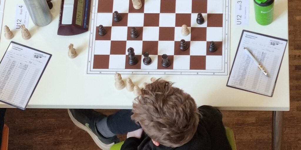 Kind spielt konzentriert ein Schachturnier am Brett