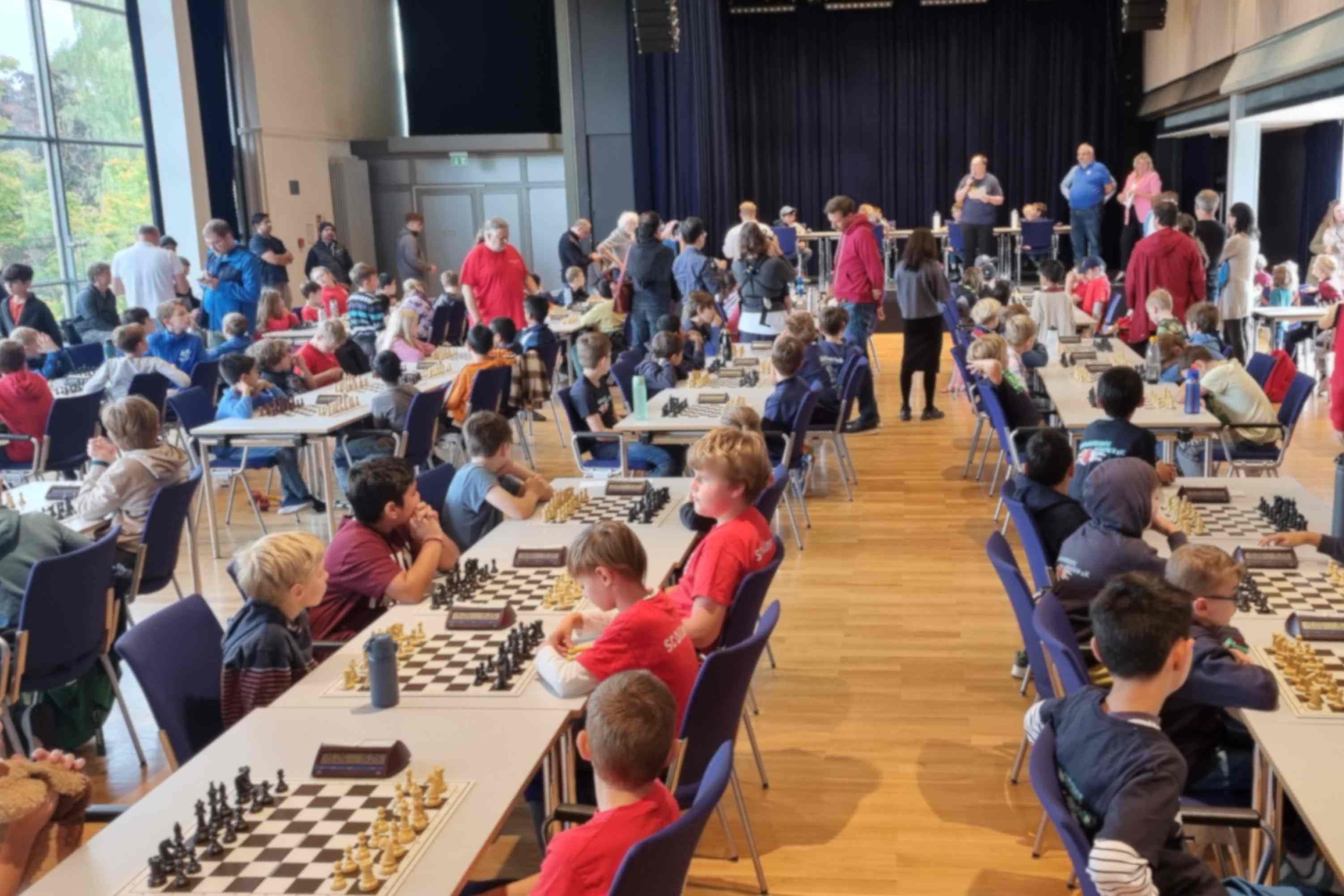 Turniersaal mit jugendlichen Schachspielern am Brett
